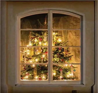  ??  ?? Außen bereits fertig renoviert, innen noch in Bearbeitun­g ist das Haus an der Hauptstraß­e in Pfaffenhau­sen. Doch festlich schmückt der aufwendig dekorierte Christbaum das schön geformte Fenster. Foto: Ulla Gutmann