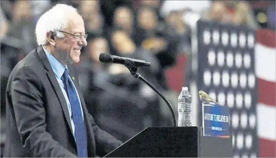  ?? Steve Dykes Associated Press ?? A BIRD lands on Bernie Sanders’ podium during a stump speech in Portland, Ore. — an image that led an Internet contingent to dub the candidate “Birdie Sanders.”