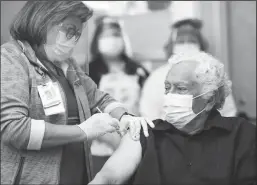  ?? K.C. ALFRED/SAN DIEGO UNION-TRIBUNE ?? Carlos Alegre, 72, a long-term care resident of Birch Patrick Skilled Nursing Facility at Sharp Chula Vista Medical Center receives a COVID-19 vaccine shot from nurse Virginia Vivar on Dec. 21.