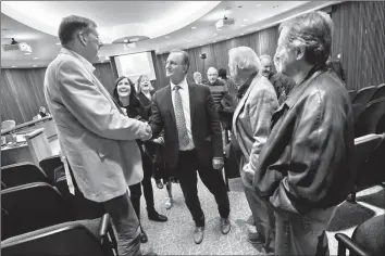  ?? Herald photo by Ian Martens ?? City manager Garth Sherwin is congratula­ted by former mayors David Carpenter and Rajko Dodic after the announceme­nt of his retirement during Tuesday’s council meeting at city hall. @IMartensHe­rald