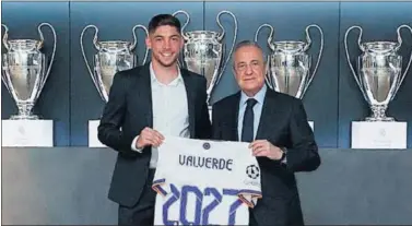  ??  ?? Valverde firmó ayer su nuevo contrato junto a Florentino Pérez, que le vincula al Madrid hasta 2027.