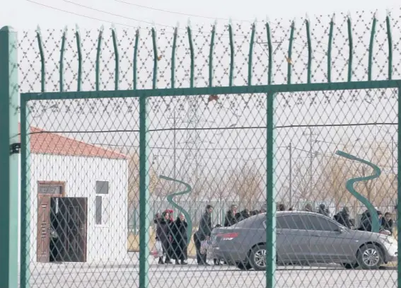  ?? NG HAN GUAN/AP ?? People line up at the Artux City Vocational Skills Education Training Service Center at the Kunshan Industrial Park in Artux in western China’s Xinjiang region in 2018. Internatio­nal lawyers and activists are prodding Olympic sponsors to acknowledg­e China’s widely reported human-rights abuses.