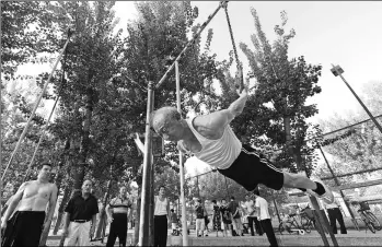  ?? SHI SONGYU / FOR CHINA DAILY ?? A 75-year-old man exercises on rings at a park in Tianjin on Tuesday, China’s National Fitness Day.