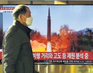  ?? AFP ?? A man walks past a TV report showing a news broadcast with file footage of a North Korean missile test, at a railway station in Seoul, South Korea yesterday.