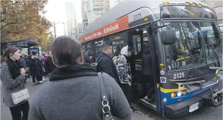  ??  ?? Downtown commuters wait to board a bus during limited job action in Vancouver this month.