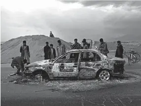  ?? RAHMAT GUL/AP ?? Afghans examine a burnt vehicle following an attack that claimed four U.S. lives in 2019 near the Bagram Air Base in Afghanista­n. The Taliban claimed responsibi­lity for the attack.