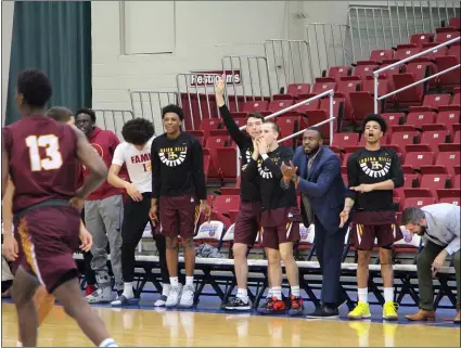  ?? SUBMITTED PHOTO ?? Assistant coach Kevon Davis (blue suit, third from right) cheers on players from the bench at Indian Hill Community College in Iowa. The Upper Darby grad has carved out a career as a basketball assistant coach all over the country for the last 10years.