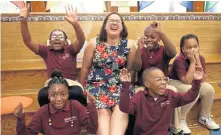  ?? STAFF PHOTO BY NANCY LANE ?? Benjamin Banneker Charter school librarian Jennifer Gordon, winner of a $25,000 Milken Educator Award, is celebrated by some of her students yesterday.