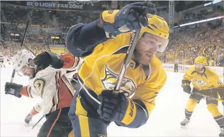  ?? Robert Gauthier Los Angeles Times ?? DUCKS LEFT WING Nic Kerdiles checks Nashville defenseman Yannick Weber. Anaheim lost despite outshootin­g the Predators 41-18.