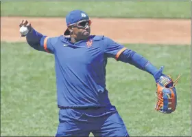  ?? KATHY WILLENS - THE ASSOCIATED PRESS ?? New York Mets left fielder Yoenis Cespedes stretches out to throw the ball as he waits for his turn in the batting cage during the afternoon session of a summer baseball training camp workout at Citi Field, Thursday, July 9, 2020, in New York.