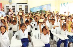  ?? CONTRIBUTE­D FOTO ?? HIGH ENERGY. Young beneficiar­ies of Therma Visayas’ wellness and nutrition program raise their first share of high-energy biscuits during the project launch.