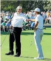  ??  ?? Tiger Woods and Phil Mickelson fistbump after winning a hole during their practice round.