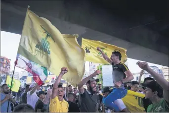  ?? HASSAN AMMAR — THE ASSOCIATED PRESS FILE ?? In this June 28, 2020 file photo, Hezbollah and Amal supporters wave Hezbollah and Iranian flags as they shout slogans against Israel and U.S. during a protest in the southern suburb of Beirut, Lebanon. For many, the Iran-backed Hezbollah now stands at the top of Lebanon’s sectarian-based system of power — and so is complicit in the corruption many blame for the port disaster and for driving the country into near bankruptcy.