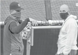  ?? ADRIAN KRAUS/AP ?? Yankees manager Aaron Boone, left, talks with general manager Brian Cashman during batting practice before a game against the Toronto Blue Jays on Sept. 7.