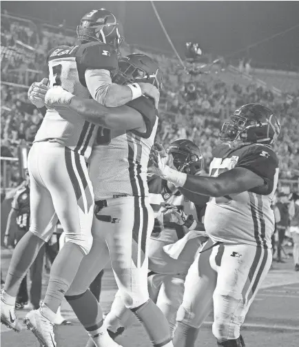  ?? PHELAN M. EBENHACK, AP ?? Orlando Apollos quarterbac­k Garrett Gilbert, left, is congratula­ted by teammates after catching a pass from receiver Jalin Marshall for a 5-yard touchdown during the first half of an Alliance of American Ffootball game against the Atlanta Legends .