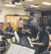  ??  ?? Part of the CCI orchestra rehearsing, led by musical director Mr. Paul McCorristo­n (guitar player, centre)