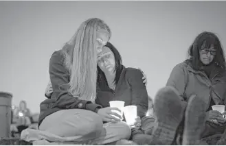  ?? John Locher / Associated Press ?? Heidi Wickersham, left, embraces her sister Gwendoline Wickersham during a prayer vigil in honor of the victims of the fatal shooting at Umpqua Community College in Roseburg, Ore.