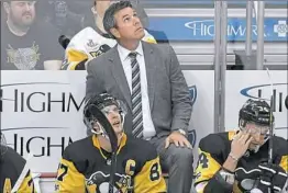  ?? Matt Freed/Post-Gazette ?? Coach Mike Sullivan checks the scoreboard in an early season game at PPG Paints Arena. This season has been trying at times, but Sullivan’s evenkeel demeanor has helped keep everyone on the same page.