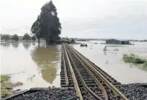  ?? PHOTO: JOHN COSGROVE ?? Water gauge . . . The railway line surrounded by water near Balclutha yesterday morning.