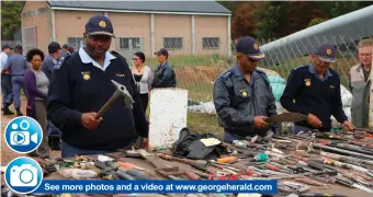  ??  ?? See more photos and a video at www.georgehera­ld.comDeputy commander of George cluster, Brigadier Phumzile Cetyana, Major-General Oswald Reddy and Conville Police station commander, Colonel AB Kriga, look at the weapons that were seized.