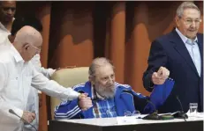  ??  ?? HAVANA: Fidel Castro sits as he clasps hands with his brother, Cuban President Raul Castro (right) and second secretary of the Central Committee, Jose Ramon Machado Ventura, moments before the playing of the Communist party hymn during the closing...