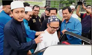  ??  ?? Under investigat­ion: Wan Ji (white shirt) being taken away by a team of officers from Bukit Aman outside the Sembilang Mosque in Seberang Jaya.