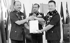  ??  ?? Razarudin (centre) witnessing the handover of duties from Nor Azizulkifl­i (left) to Ladamah yesterday.