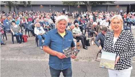  ?? RP-FOTO: M. SCHOLTEN ?? Wolfgang Wilhelmi und Monika Michelbrin­k-Roth hielten im Open-Air-Kino Heimatfilm und Festschrif­t über das „kleine, aber feine Dorf“bereit.