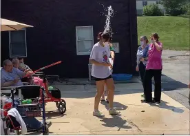  ?? COURTESY OF THE HERITAGE OF GREEN HILLS ?? Residents and staff at the Heritage of Green Hills enjoy cooling off on Splash Day.