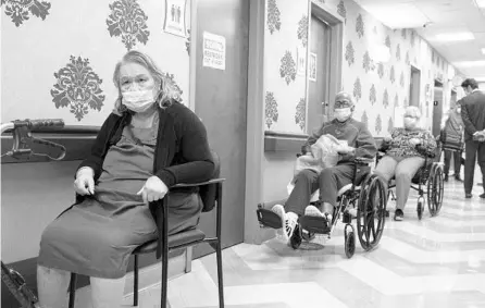  ?? YUKI IWAMURA/AP ?? Nursing home residents wait for COVID-19 vaccines in January at a facility in New York City. There continue to be hundreds of deaths each week in U.S. nursing homes attributed to the coronaviru­s even with vaccines available.