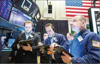  ?? (AP) ?? Traders work on the floor at the New York Stock Exchange Friday, May 6, 2022 in New York. Stocks are swinging sharply on Friday. The S&P 500 was 0.5% lower in afternoon trading but only after careening from a steep morning loss to a brief, small gain. Wall Street is struggling with how to interpret a strong U.S. jobs report amid worries the Federal Reserve may cause a recession in its drive to halt inflation.