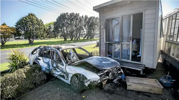  ?? ANDY JACKSON/STUFF ?? A car crashed into a parked car and narrowly missed a house before catching fire on the corner of Parris and Cracroft streets in Waitara on Wednesday night.