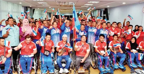  ??  ?? DCM Kontinjen Paralimpik Sabah Haji Awang Damit Awang Anak menerima bendera Sabah daripada Datuk Haji Tawfiq.