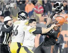  ?? JASON MILLER/GETTY ?? Browns DE Myles Garrett, right, initiated a brawl Thursday night when he removed the helmet of Steelers QB Mason Rudolph, center, and struck him with it.