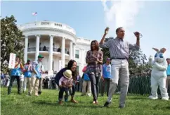  ?? CAROLYN KASTER/THE ASSOCIATED PRESS ?? President Barack Obama and first lady Michelle Obama cheer and applaud as they host a White House Easter Egg Roll on the South Lawn of the White House.