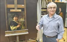  ?? Darrell Sapp/Post-Gazette ?? Costas Karakatsan­is with “Shepherd Boy With Recorder,” a painting on wood that is part of “Created, Collected, Conserved” at Carnegie Museum of Art.