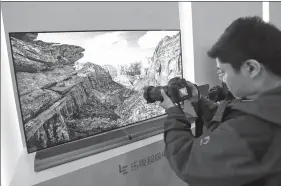  ?? QUAN YAJUN / CHINA DAILY ?? A visitor takes photograph­s of a smart television produced by LeEco at a high-tech exhibition in
Beijing.