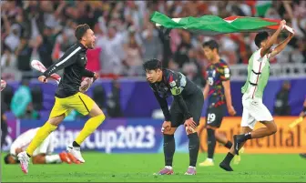  ?? REUTERS ?? South Korea's Son Heung-min cuts a dejected figure as jubilant Jordan players celebrate their 2-0 semifinal victory at Ahmed bin Ali Stadium in Al Rayyan, Qatar, on Tuesday. The win sees Jordan progress to its first ever Asian Cup final.