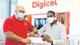  ??  ?? Jeremy Owen (left), general manager sales and distributi­on at Digicel, presents Winston Scott of Needham Pen Farmers Assoiation with a Digicel Foundation ‘20 for 20’ retail grant at Digicel’s headquarte­rs, Ocean Boulevard in downtown Kingston yesterday.