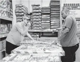  ?? Elizabeth Conley / Staff photograph­er ?? Allan Lopez, left, helps Mike Rossum pick the perfect fireworks to celebrate America’s birthday with a bang. Safety precaution­s should always be used when using explosives.