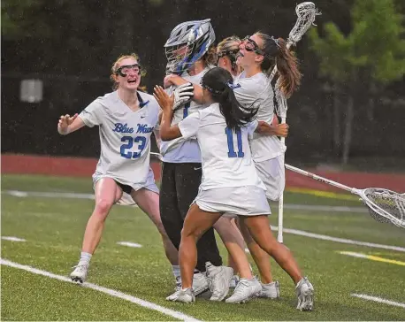  ?? Dave Stewart/Hearst Connecticu­t Media ?? Darien players, including goalie Hope Schoudel, Kate Demark (23) and Kate Min (11) begin the celebratio­n after the Blue Wave defeated New Canaan for the FCIAC girls lacrosse championsh­ip in Greenwich on Thursday.