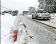  ?? ALLEN G. BREED—ASSOCIATED PRESS ?? A car drives slowly down Old NC 98 in Wake Forest, N.C., on Sunday, Dec. 9, 2018. A storm spreading snow, sleet and freezing rain across a wide swath of the South has millions of people in its path, raising the threat of immobilizi­ng snowfalls, icy roads and possible power outages.