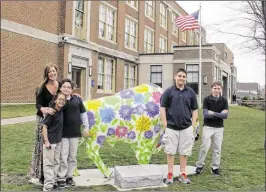  ?? CAROLYN THOMPSON / ASSOCIATED PRESS 2016 ?? From left: Teacher Kelly Gasior and students Olivia Mashtaire, Ryan Lysek, Christian Vasquez and Tyler Lysek stand by a sculpture of a buffalo outside Lorraine Academy in Buffalo, N.Y., that has been covered with anti-bullying messages. A new federal...