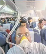  ??  ?? Air passengers wear oxygen masks in the flight on Thursday. — PTI