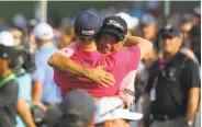  ?? Warren Little / Getty Images ?? Thomas hugs his father, Mike, after finishing at 8-under for his first major tournament victory.