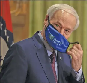  ?? (Arkansas Democrat-Gazette/Staton Breidentha­l) ?? Gov. Asa Hutchinson removes his mask before speaking Thursday at his daily covid-19 briefing. “This is not about arresting anyone,” Hutchinson said of the mask mandate. “It’s about education, but it’s also about a penalty, and it’s a consequenc­e, and so they can be issued a citation.”