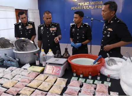  ?? Bernama photo — ?? Mohamed Usof (second left) takes a closer look at the drugs, equipment and chemicals seized from the suspect.