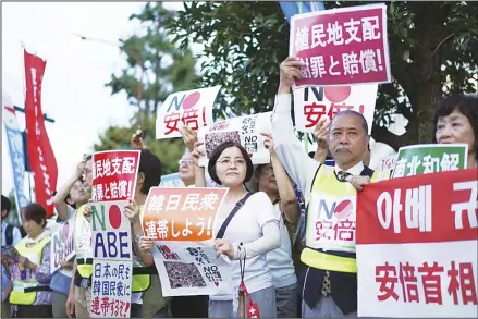  ??  ?? A group of protesters gather outside Japanese Prime Minister Shinzo Abe’s residence in Tokyo Thursday, Aug. 8, 2019. They staged a rally with placards to urge the government to apologize for wartime atrocities in an effort fix rapidly souring relations. Japan has approved shipment of a high-tech material
to South Korea for the first time since imposing export curbs last month. (AP)