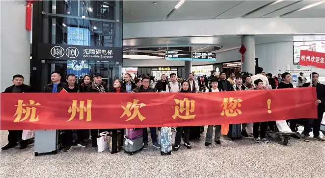  ?? ?? Workers from Guangyuan are welcomed with banners at Hangzhou Xiaoshan Internatio­nal Airport. — Photos by Ti Gong