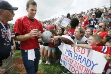  ?? STEVEN SENNE — THE ASSOCIATED PRESS ?? New England Patriots’ Tom Brady, center left, signs autographs for fans at NFL football training camp, Thursday in Foxborough, Mass. Brady turned 40-years-old Thursday.